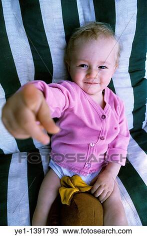 One year old baby girl pointing and smiling View Large Photo Image Stock Image - One year old baby girl pointing and smiling. Fotosearch