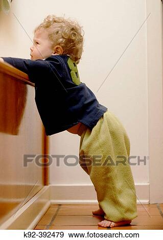 Stock Photo - One year old boy leaning against the base of a bathtub.. Fotosearch