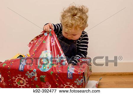 One year old boy opening a Christmas present View Large Photo Image Stock Photo - One year old boy opening a Christmas present. Fotosearch
