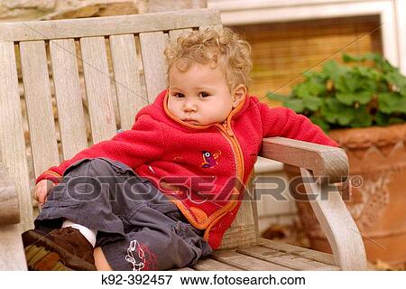 One year old boy sitting on a deck chair View Large Photo Image Stock Photo - One year old boy sitting on a deck chair. Fotosearch