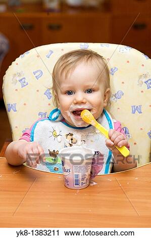 One year old dirty baby girl eating yogurt using spoon View Large Photo Image Stock Image - One year old dirty baby girl eating yogurt using spoon. Fotosearch