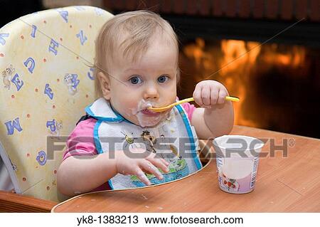 One year old dirty baby girl in high chair eating yogurt using spoon View Large Photo Image Stock Image - One year old dirty baby girl in high chair eating yogurt using spoon. Fotosearch