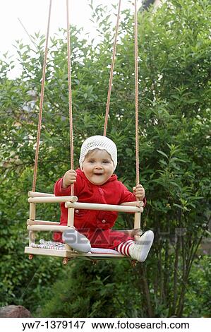 One year old girl on a garden swing View Large Photo Image Stock Photo - One year old girl on a garden swing. Fotosearch