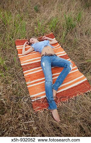 one young woman laying-down in the grass View Large Photo Image Stock Image - one young woman laying-down in the grass. Fotosearch