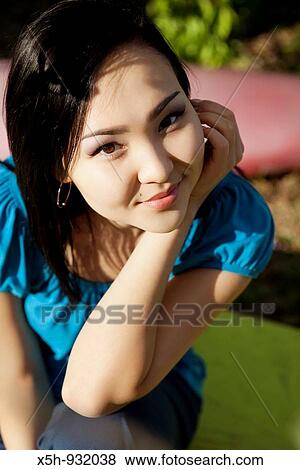 Stock Photo - one young woman smiling outdoor. Fotosearch