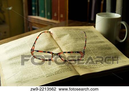 Stock Image - Open old book with a cup and glasses, Madrid, Spain. Fotosearch