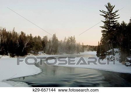 Picture - Open water of Wahnapitei River above rapids before dawn on a cold winter morning. Ontario, Canada. Fotosearch