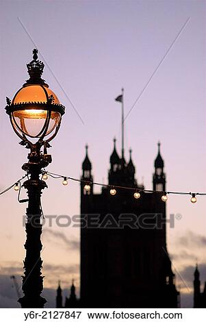 Ornate Victorian streetlamp on the South Bank of the River Thames opposite the Houses of Parliament, in the heart of London, England, at nightfall. View Large Photo Image Stock Photo - Ornate Victorian streetlamp on the South Bank of the River Thames opposite the Houses of Parliament, in the heart of London, England, at nightfall.. Fotosearch