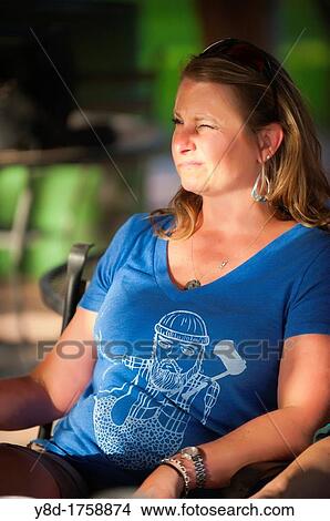 Outdoot portrait of 45 years old woman sitting relaxed on a table View Large Photo Image Picture - Outdoot portrait of 45 years old woman sitting relaxed on a table. Fotosearch