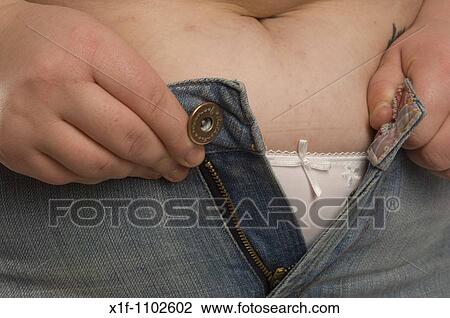 Overweight woman trying to squeeze into her denim jeans View Large Photo Image Stock Image - Overweight woman trying to squeeze into her denim jeans. Fotosearch