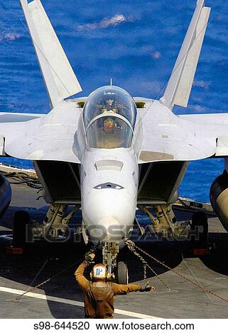 Stock Image - Pacific Ocean (June 22, 2006) - A plane captain directs an F/A-18F Superhornet aircrew as they perform control surface checks prior to takeoff on the flightdeck of the Nimitz-class aircraft carrier USS Abraham Lincoln (CVN-72). . Fotosearch
