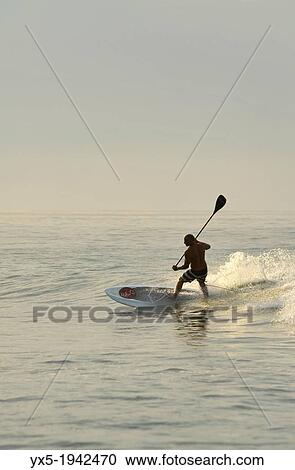 Stock Image - Paddleboarding on a beach near Puerto Vallarta, Mexico.. Fotosearch