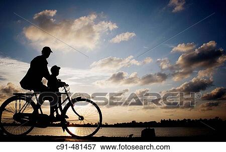 Padre e Hijo en bicicleta al atardecer View Large Photo Image Stock Photo - Padre e Hijo en bicicleta al atardecer. Fotosearch