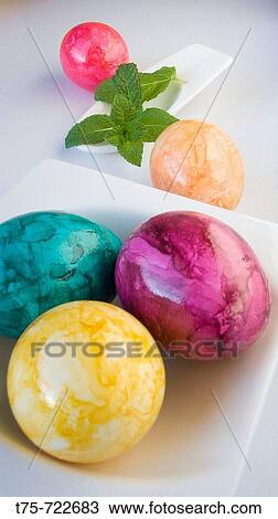 Stock Image - Painted hard-boiled eggs and basil. Fotosearch