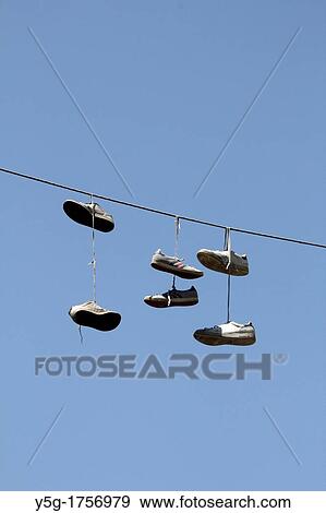 pairs of sports shoes hanging from power lines in rome italy View Large Photo Image Stock Photo - pairs of sports shoes hanging from power lines in rome italy. Fotosearch