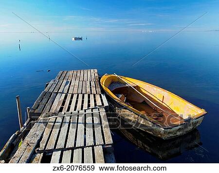 Pallet pier and small fishing boat at Alfacs Bay. Ebro River Delta Natural Park, Tarragona province, Catalonia, Spain. View Large Photo Image Stock Photo - Pallet pier and small fishing boat at Alfacs Bay. Ebro River Delta Natural Park, Tarragona province, Catalonia, Spain.. Fotosearch