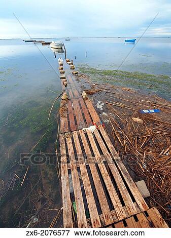 Pallet pier and small fishing boats at Alfacs Bay. Ebro River Delta Natural Park, Tarragona province, Catalonia, Spain. View Large Photo Image Stock Photo - Pallet pier and small fishing boats at Alfacs Bay. Ebro River Delta Natural Park, Tarragona province, Catalonia, Spain.. Fotosearch