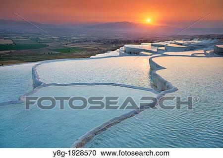 Stock Image - Pamukkale, sunset view of the limestone terraces, Pamukkale near Denizli, Turkey. Fotosearch