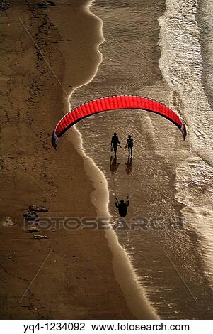 Stock Image - Paragliding and couples strolling on the beach Torimbia, Llanes, Asturias. Fotosearch