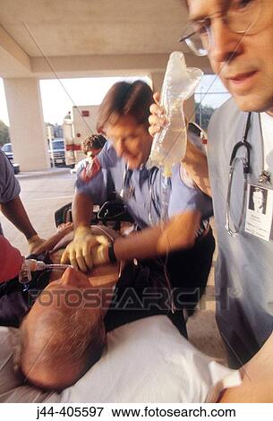 Stock Photo - Paramedics rushing patient from ambulance to emergency in hospital. Fotosearch