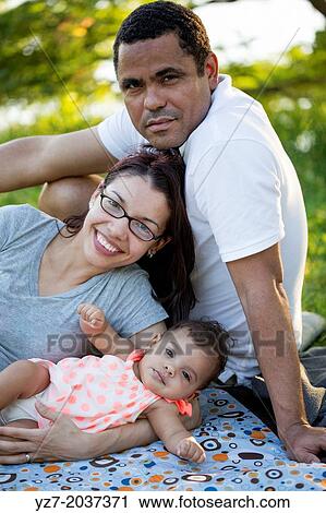 Parents posing with 5 month old baby in park. View Large Photo Image Stock Image - Parents posing with 5 month old baby in park.. Fotosearch