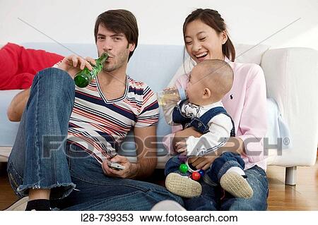 Parents with baby boy (6-11 months) sitting on sofa, smiling View Large Photo Image Stock Image - Parents with baby boy (6-11 months) sitting on sofa, smiling. Fotosearch