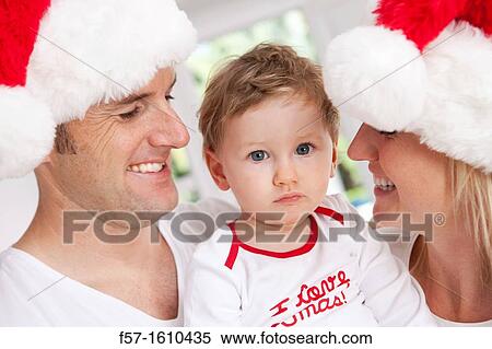 Parents with their one year old son at Christmas time View Large Photo Image Stock Photography - Parents with their one year old son at Christmas time. Fotosearch