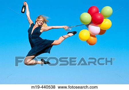 Stock Photo - party girl jumping with balloons. Fotosearch