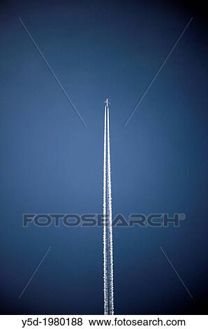 Passenger jet liner flying at high altitude leaving vapour trails against a clear dark blue sky View Large Photo Image Stock Photo - Passenger jet liner flying at high altitude leaving vapour trails against a clear dark blue sky. Fotosearch