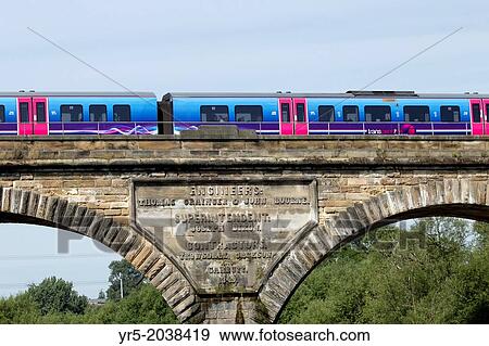 Stock Photo - Passenger train crossing viaduct over the river Tees on the East coast line at Yarm near Stockton on Tees, England, United Kingdom.. Fotosearch
