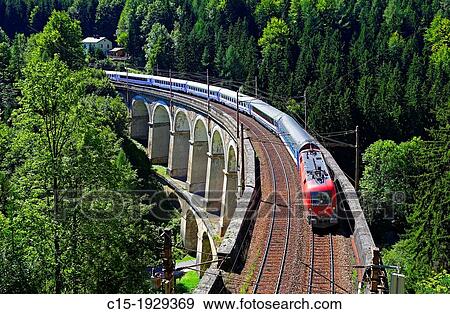 Stock Photo - Passenger train on the Kalte Rinne Viaduct, UNESCO World Heritage Site, built 1848-1854. Fotosearch