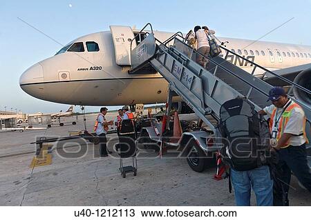 Stock Image - Passengers boarding plane. Fotosearch