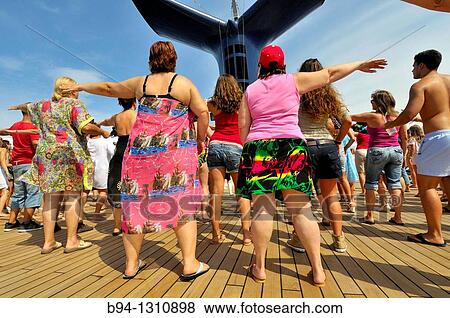 Stock Photo - Passengers dancing on the deck of a cruise ship. Fotosearch