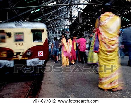 Stock Image - Passengers in Victoria Central Station, Bombay (Mumbai), India. Fotosearch