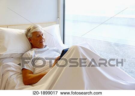 Stock Photo - patient with tablet in hospital room, Onkologikoa Hospital, Oncology Institute, Case Center for prevention, diagnosis and treatment of cancer, Donostia, San Sebastian, Gipuzkoa, Basque Country, Spain. Fotosearch