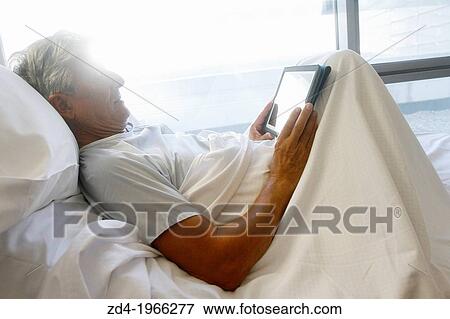 Patient with tablet in hospital room, Onkologikoa Hospital, Oncology Institute, Case Center for prevention, diagnosis and treatment of cancer, Donostia, San Sebastian, Gipuzkoa, Basque Country, Spain View Large Photo Image Stock Photo - Patient with tablet in hospital room, Onkologikoa Hospital, Oncology Institute, Case Center for prevention, diagnosis and treatment of cancer, Donostia, San Sebastian, Gipuzkoa, Basque Country, Spain. Fotosearch