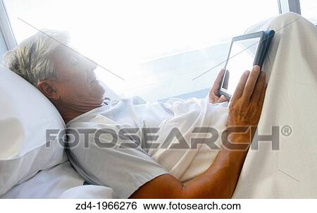 Patient with tablet in hospital room, Onkologikoa Hospital, Oncology Institute, Case Center for prevention, diagnosis and treatment of cancer, Donostia, San Sebastian, Gipuzkoa, Basque Country, Spain View Large Photo Image Stock Photograph - Patient with tablet in hospital room, Onkologikoa Hospital, Oncology Institute, Case Center for prevention, diagnosis and treatment of cancer, Donostia, San Sebastian, Gipuzkoa, Basque Country, Spain. Fotosearch