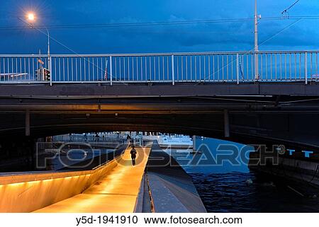 Stock Image - pedestrian passage under Mt Blanc bridge on Rhone river, at dusk, Geneva, Switzerland.. Fotosearch