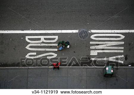 Stock Photo - Pedestrians walk past a BUS ONLY street sign in Manhattan. Fotosearch