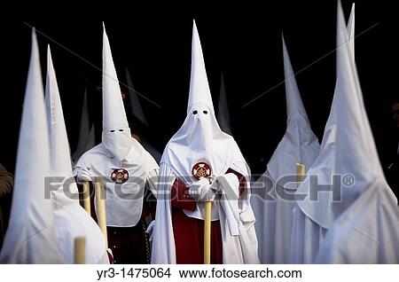 Picture - Penitents walk in the Orange Trees Court, Patio de los Naranjos in Spanish, in the Mosque-Cathedral of Cordoba during Easter Holy Week celebrations in Cordoba, Andalusia, Spain, April 18, 2011. Fotosearch