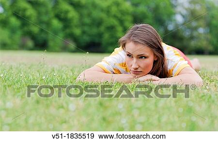 Stock Photo - Pensive woman lying in park. Fotosearch