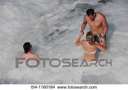 People bathe in the white waters of the Isar in Munich View Large Photo Image Picture - People bathe in the white waters of the Isar in Munich. Fotosearch