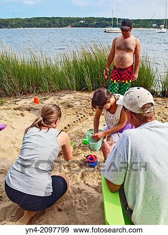 People building a sandcastle on a private beach. View Large Photo Image Stock Photo - People building a sandcastle on a private beach.. Fotosearch