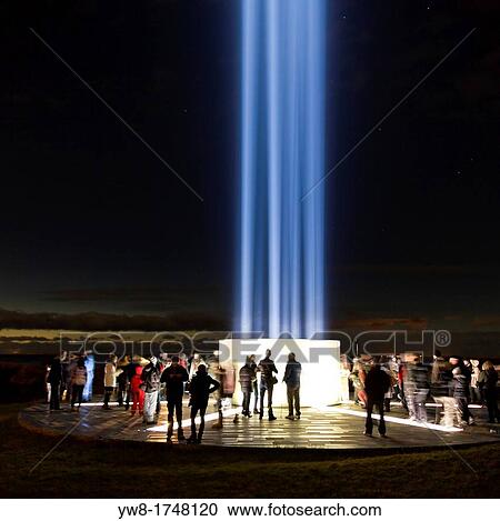 Stock Image - People celebrating the lighting of? The Imagine Peace Tower?, Videy, Reykjavik, Iceland The Imagine Peace Tower is a memorial to John Lennon from Yoko Ono, located on Videy Island, off the coast of Reykjavik, Iceland. Fotosearch