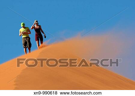 People climbing the sand dune in a windy day, Namib-Naukluft National Park, Namib desert, Namibia View Large Photo Image Stock Photo - People climbing the sand dune in a windy day, Namib-Naukluft National Park, Namib desert, Namibia. Fotosearch