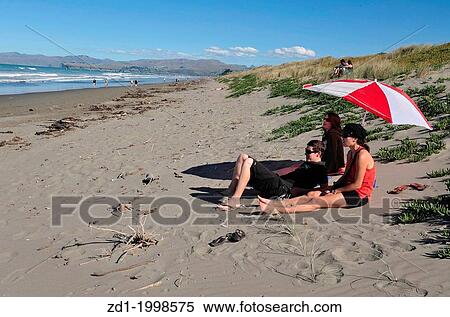 People enjoy the sea and sand at a beach in Christchurch, New Zealand. View Large Photo Image Stock Photography - People enjoy the sea and sand at a beach in Christchurch, New Zealand.. Fotosearch