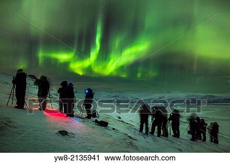 Stock Image - People enjoying and photographing the Aurora Borealis or Northern Lights at The Abisko Sky Station, Abisko, Lapland, Sweden. Cold temperatures as low as -47 celsius.. Fotosearch