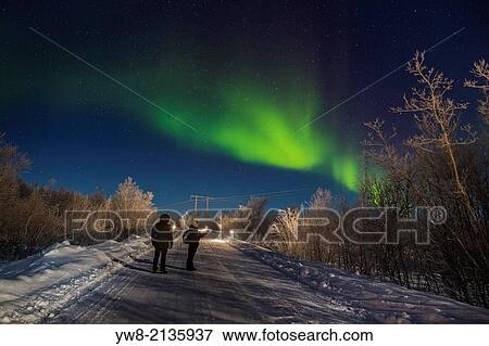 Stock Photo - People enjoying the Aurora Borealis or Northern Lights, Lapland, Sweden.. Fotosearch