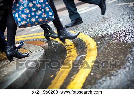 Stock Image - People in rush hour crossing the street in London, UK. Fotosearch