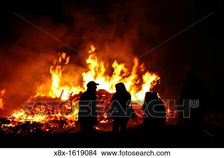 Picture - People in silhouette in front of a bonfire to celebrate the patron saint. Fotosearch